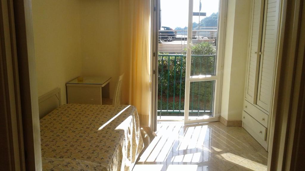 a bedroom with a bed and a large window at Hotel Feluca in Bonassola