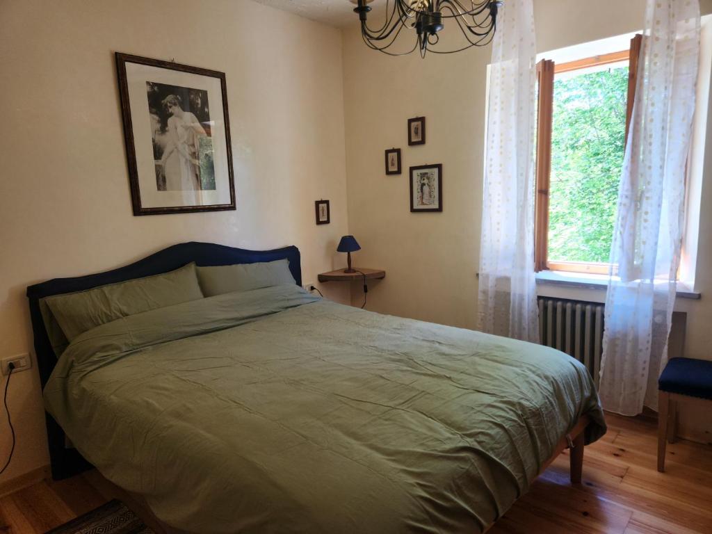 a bedroom with a bed and a window at Appartamento Sotto la Riva in Abetone