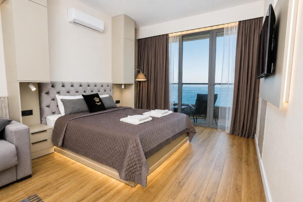 a bedroom with a bed and a large window at Mayak Bamboo Beach Apartments in Kobuleti