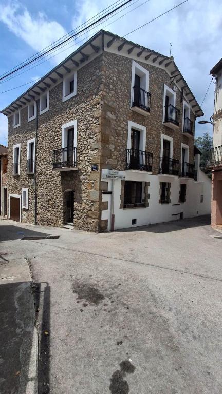 a large brick building with balconies on a street at Can Hortafa in Tortellá