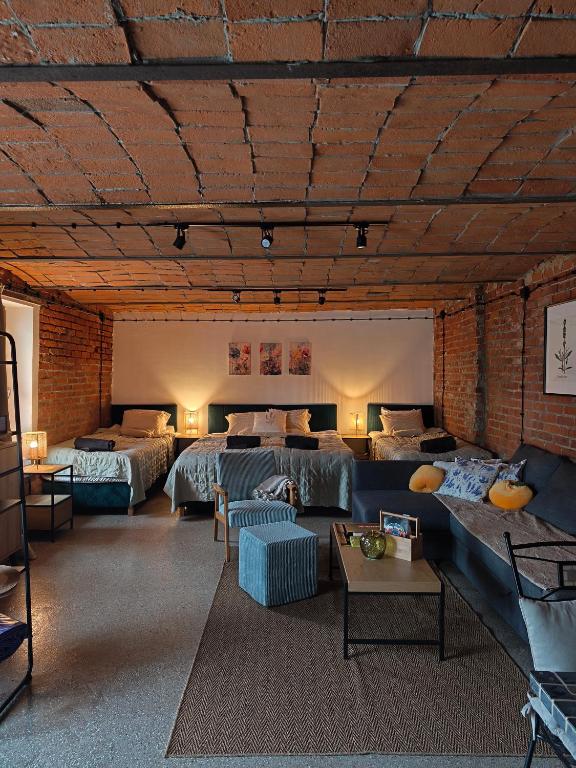 a large room with beds and a couch and tables at Studio Lawendowe Ranczo in Zawichost