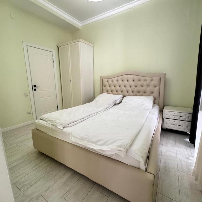a bedroom with a large bed with white sheets at Атлантис in Chon-Sary-Oy