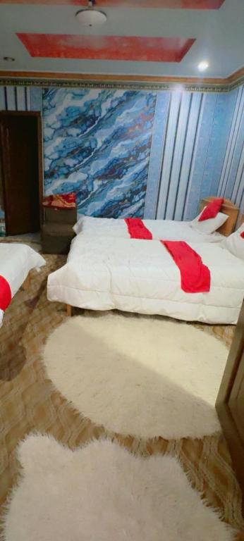 a bedroom with two beds and a painting on the wall at Ruby Bahrain Hotel in Mingāora