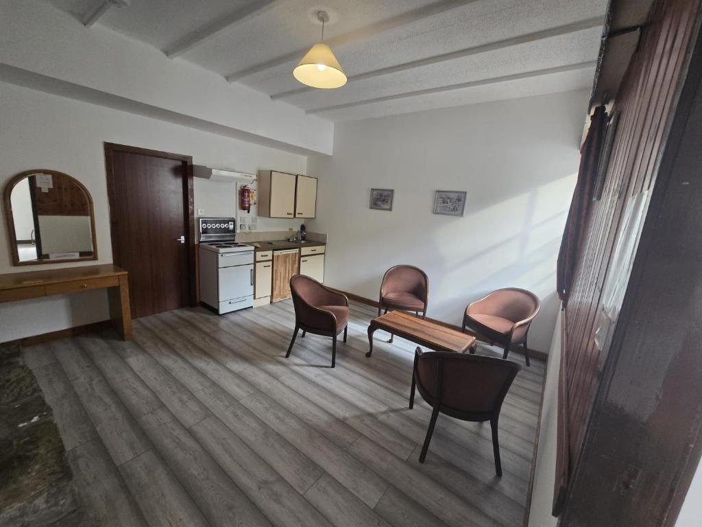 a room with chairs and a table and a kitchen at The Garve Flats in Garve