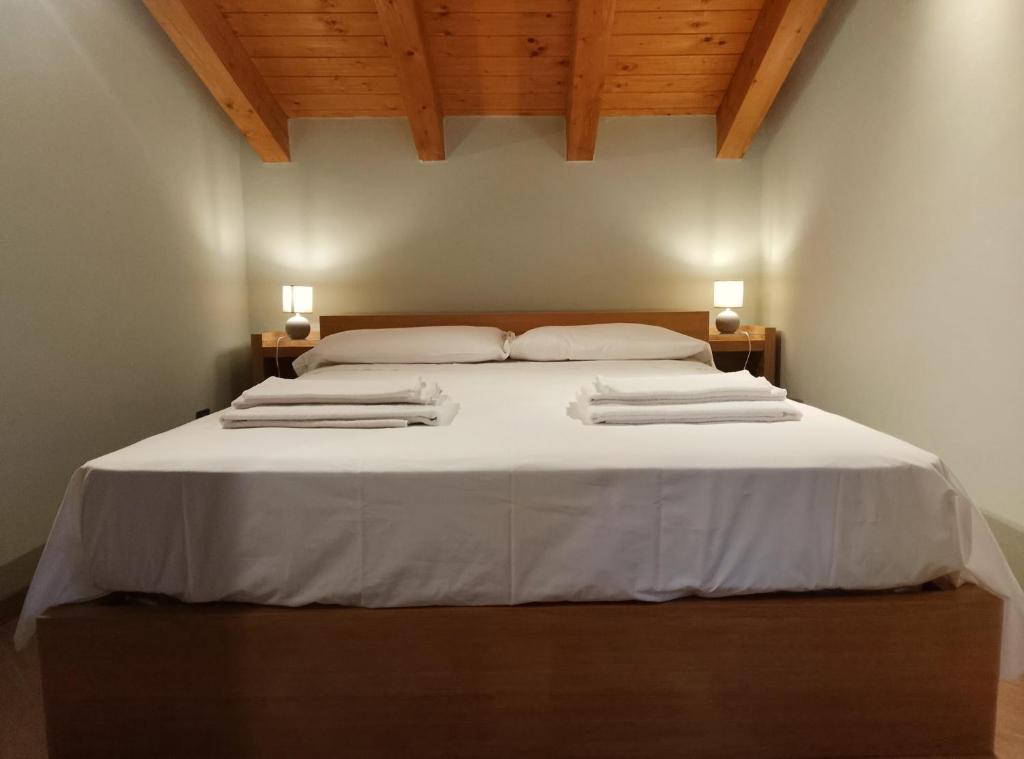 a bedroom with a large white bed with two pillows at Abri Douillet in Saint Marcel