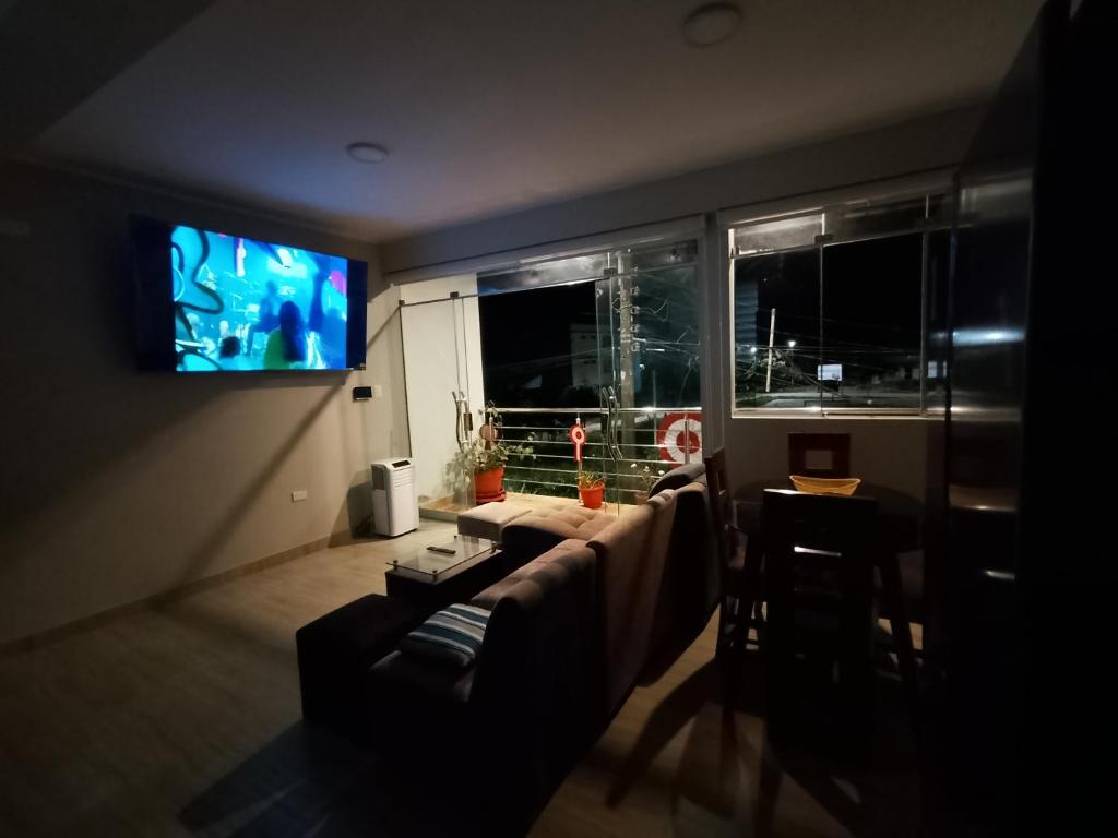 a living room with a couch and a flat screen tv at Casa Sol in Tingo María
