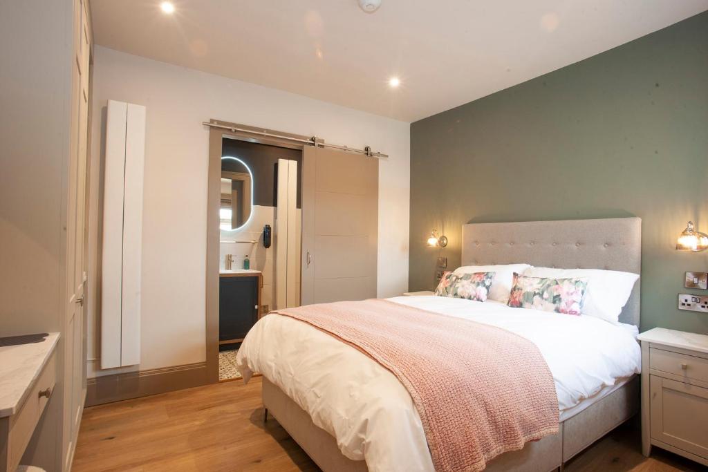 a bedroom with a large bed and a bathroom at Causeway Squarings in Bushmills