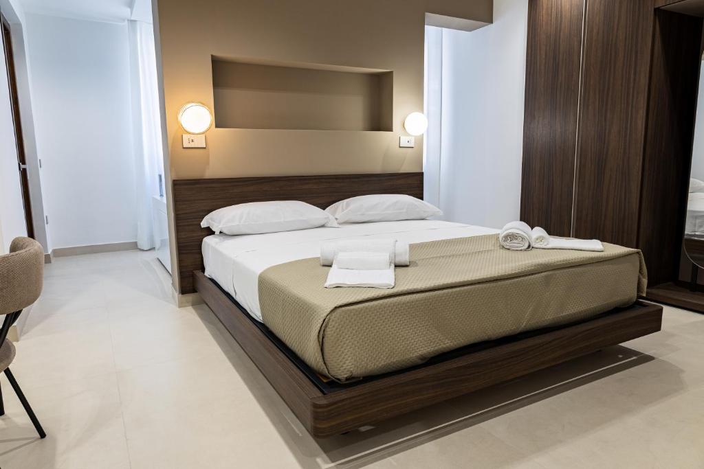 a bedroom with a large bed with white towels on it at Villa delle Rose Pompei Rooms and Suite in Pompei