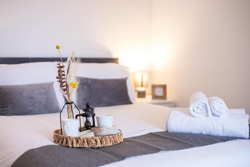 a bed with a tray with towels and mugs on it at New London 2 Bedroom, 2 Bathroom Flat in Finchley