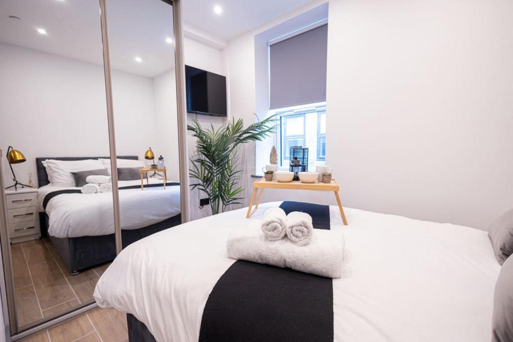 a bedroom with two beds and a mirror at Chic 2King BD Apt London with Ensuite & Pull Out Bed in Finchley