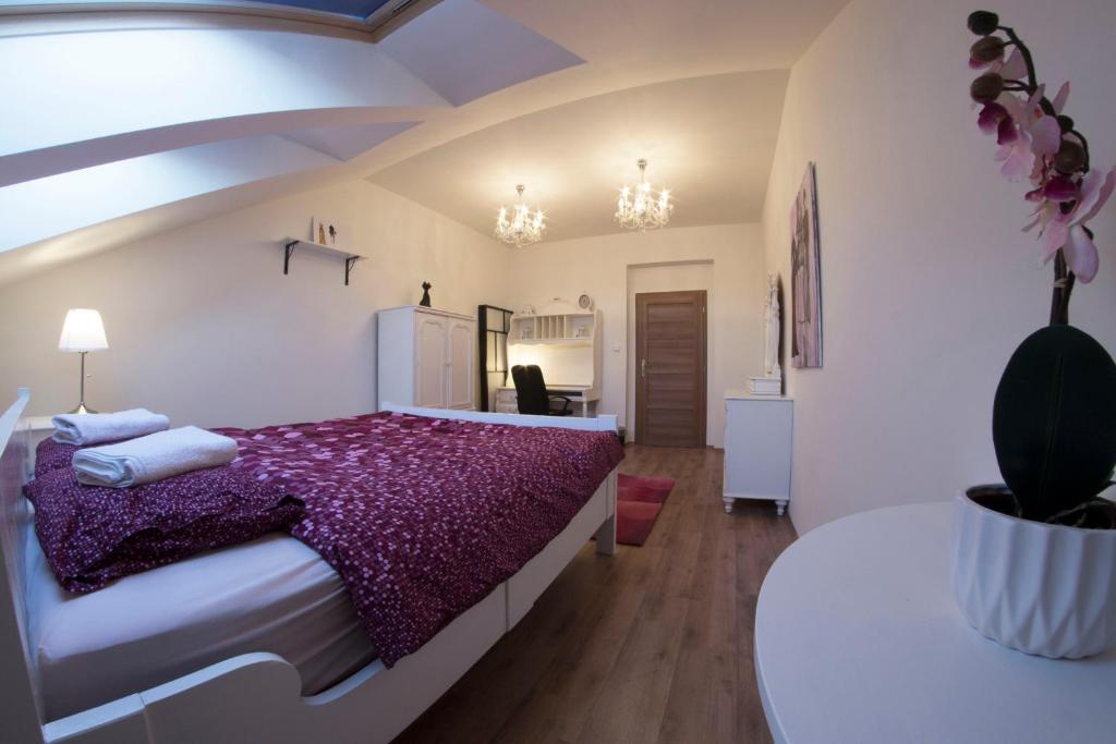 a bedroom with a large bed with a purple blanket at Prague Gate Apartments in Prague