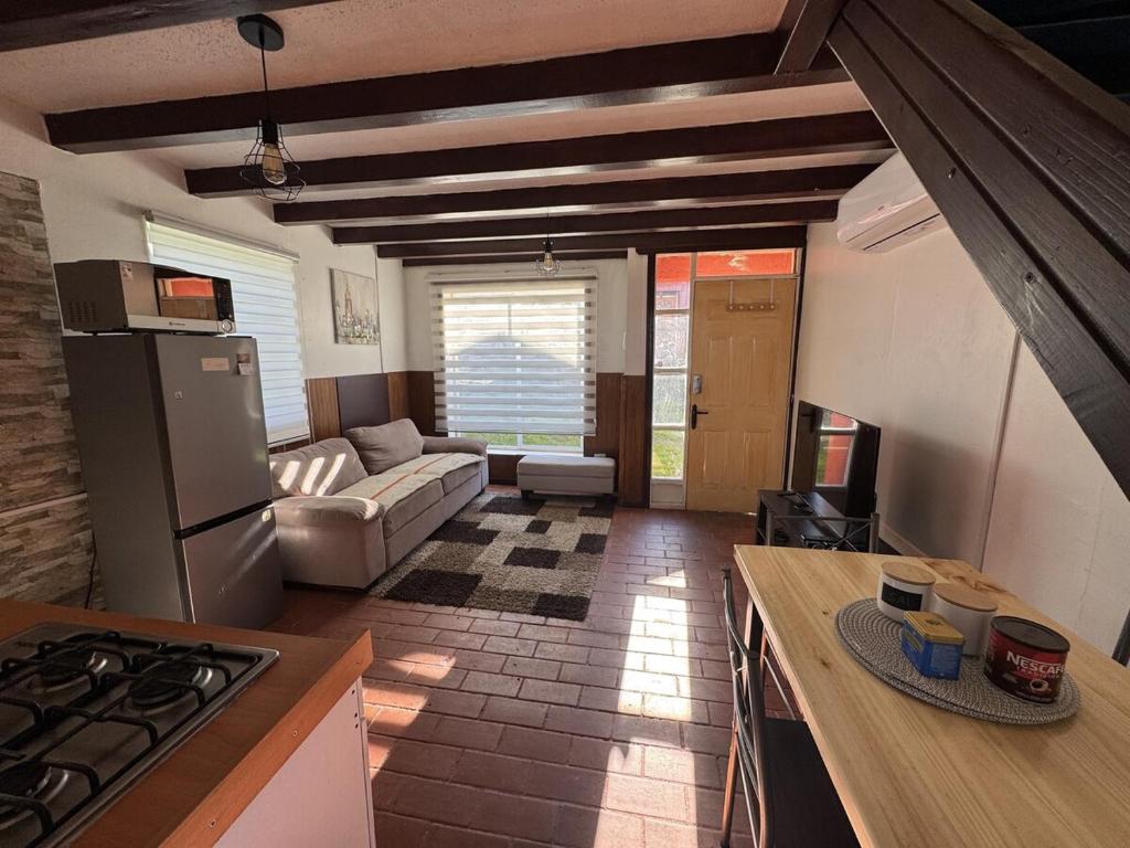 a kitchen with a stove and a couch in a room at Casa Miramar in Quellón