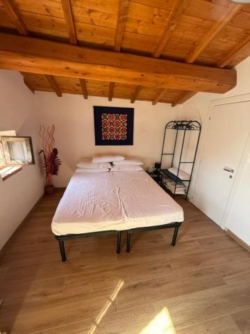 a bed in a room with a wooden ceiling at Casa vacanza Marco in Vagliano