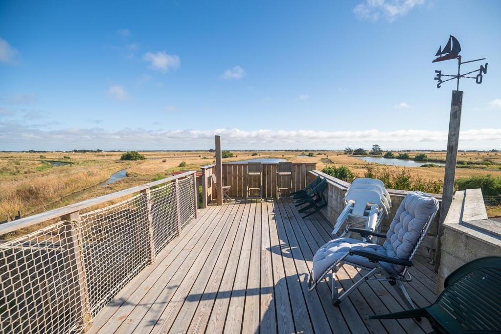 a deck with two chairs and a light pole at Escale au marais in Bouin