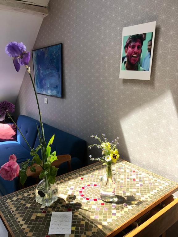 a table with vases on it with flowers on it at maison d'artiste chez Bé in Brunstatt