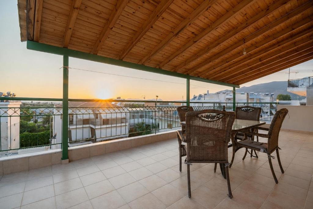 una sala da pranzo con tavolo e sedie su un balcone di SkyView Loft a Kalamáta