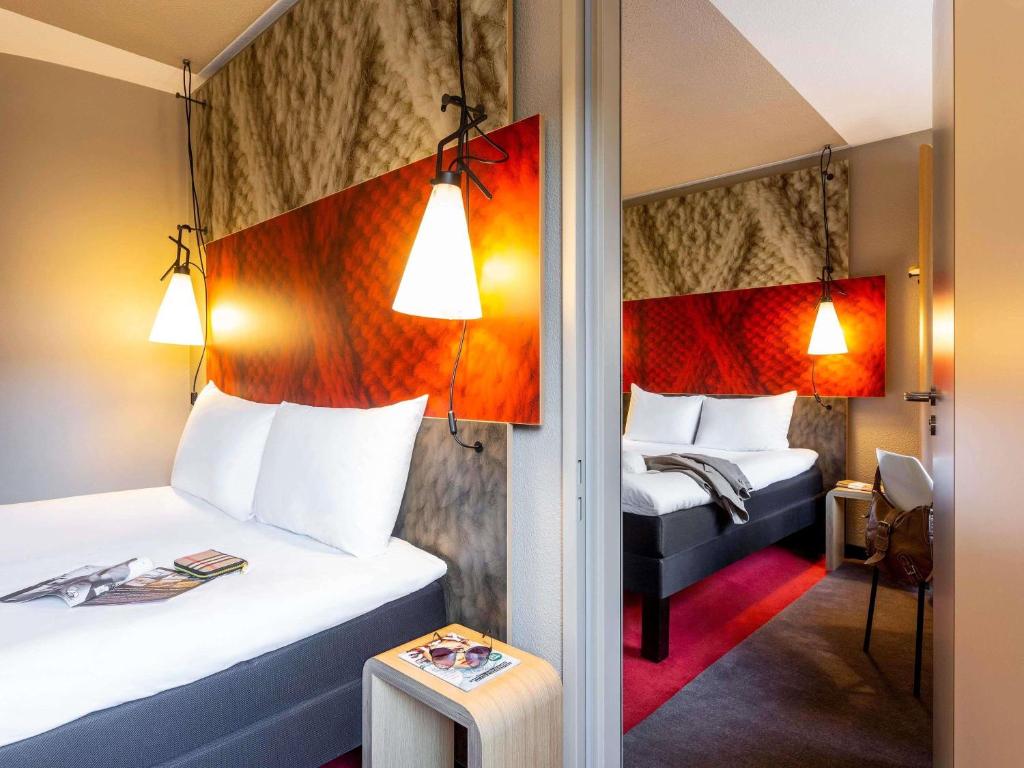 a hotel room with two beds and two lamps at ibis Hotel Hamburg St. Pauli Messe in Hamburg