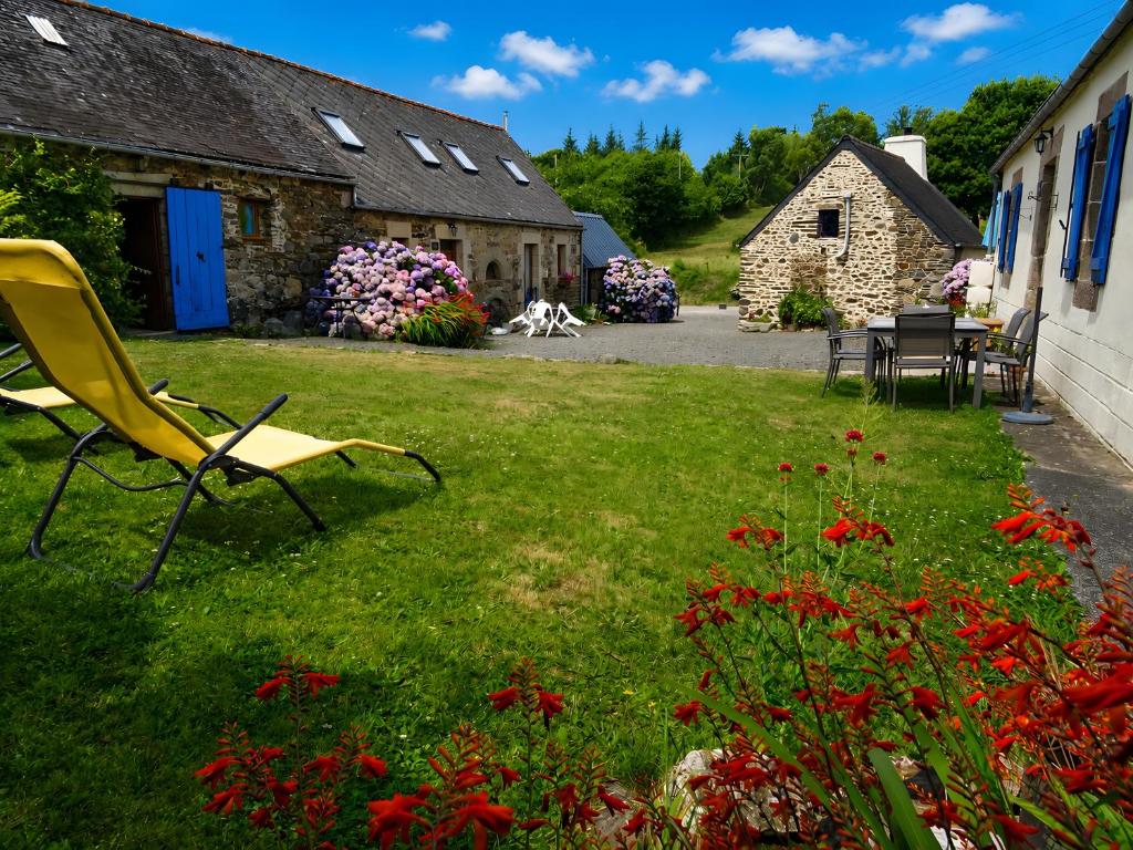 a yard with a yellow chair and some buildings at Ensemble De Gites - Pen Ar Voas in Plestin-les-Grèves