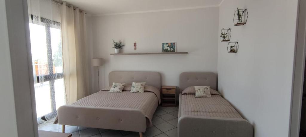 two beds in a room with two windows at Magnolia Rooms - Val Di Chy in Val di Chy