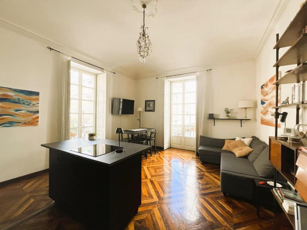 a living room with a couch and a table at Emozione Torino - affascinante, silenzioso, in palazzo d'epoca pressi piazza Solferino in Turin