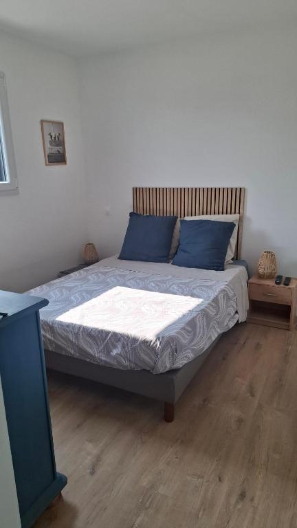 a bedroom with a bed with blue pillows on it at Chambre d'hôtes Nova, petit déjeuner en supplément 5 euros par personne in Saint-Pair-sur-Mer