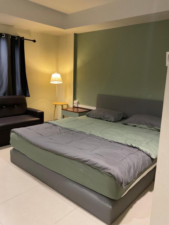 a bedroom with a large bed and a chair at Tuek Khiaw Samui Hotel in Bophut