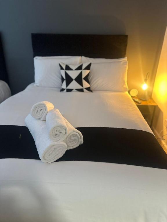 a bedroom with a bed with two rolled towels at Spacious 4-Bedrooms Corporate Flat - Prime Location in Watford