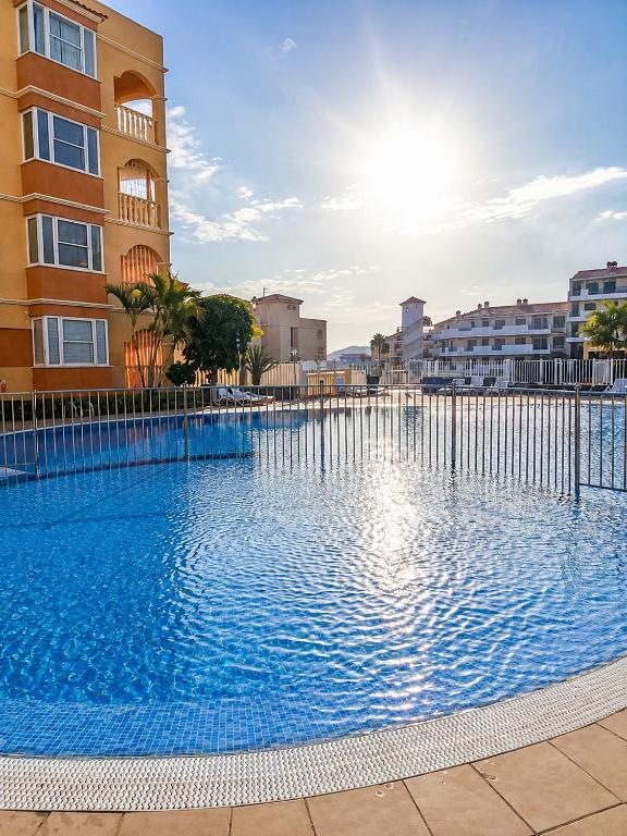 a large swimming pool in front of a building at Tamaragua Apartment, Golf del Sur in San Miguel de Abona