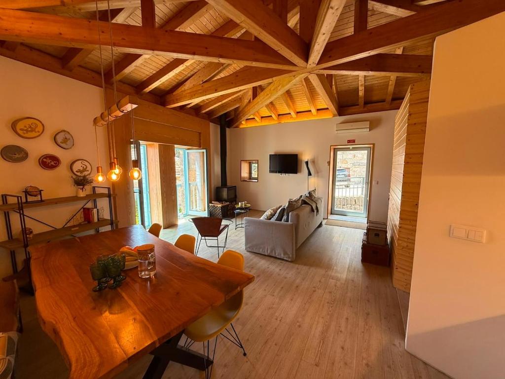 a room with a wooden table and a living room at Casa Tritão - Gerês in Campo do Gerês