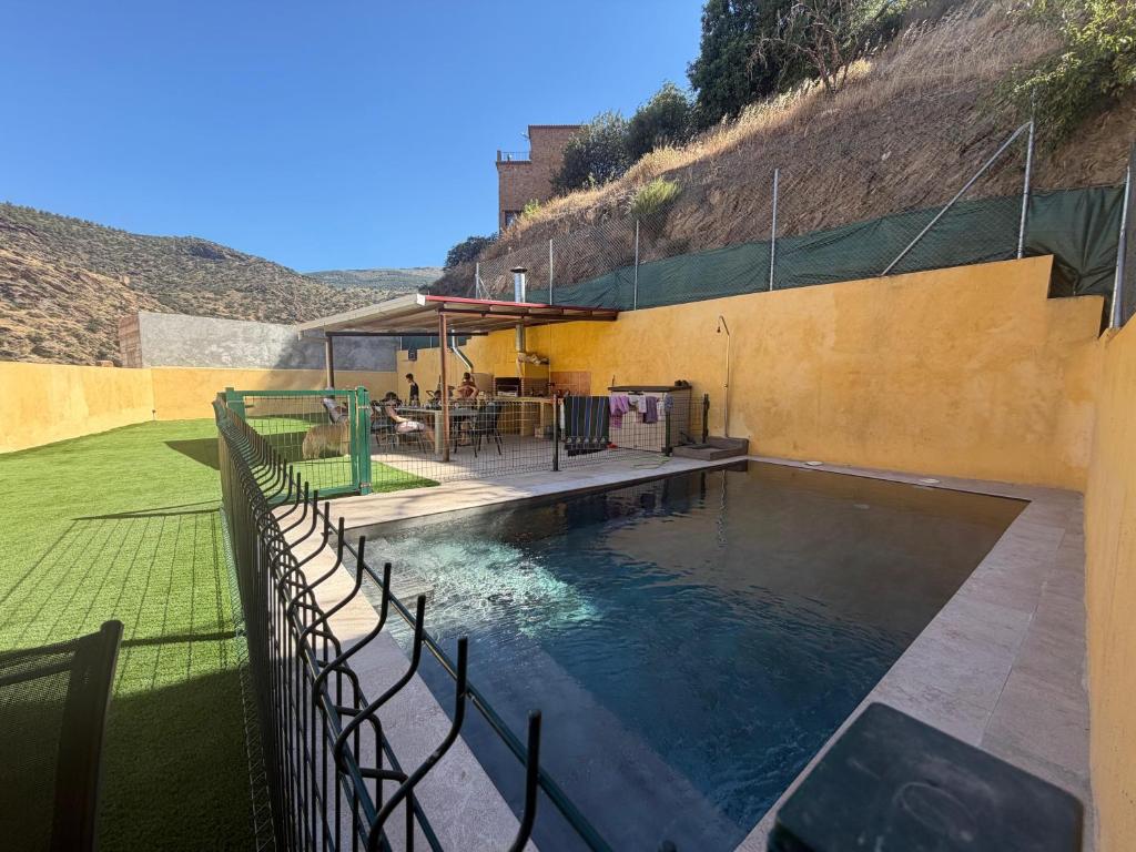 a swimming pool with a fence around it at Casa Serrano in Abrucena