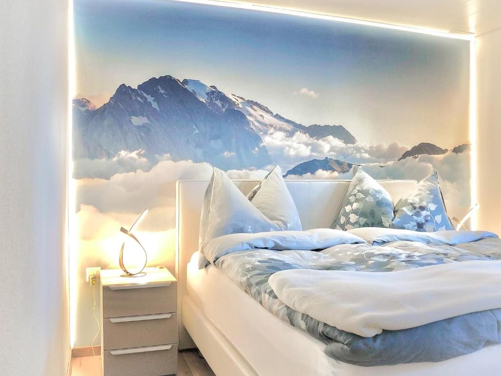 a bedroom with a mountain mural on the wall at Chalet Heimetli in Grächen