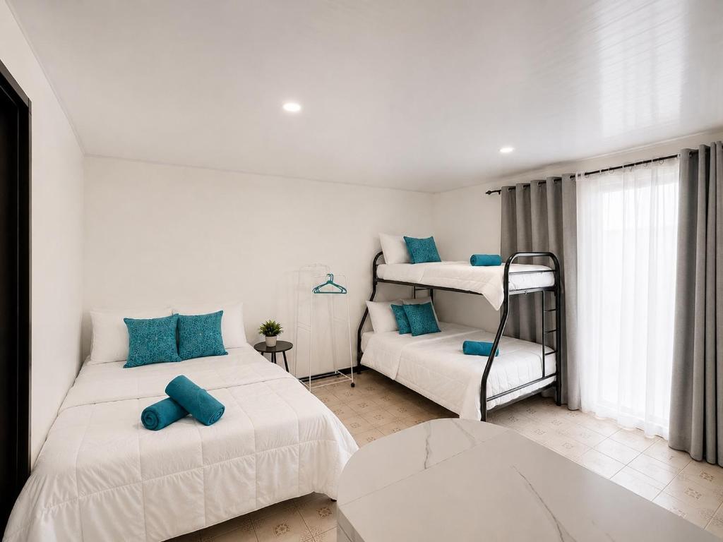 a bedroom with two beds and a bunk bed at Anluka House mono araña in Puerto Jiménez