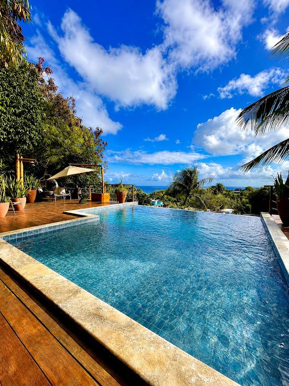 a swimming pool in a resort with a blue sky at Pousada Recanto in Fernando de Noronha