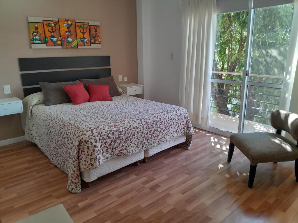 a bedroom with a bed with red pillows and a window at Aparts Lio Nell in Colón