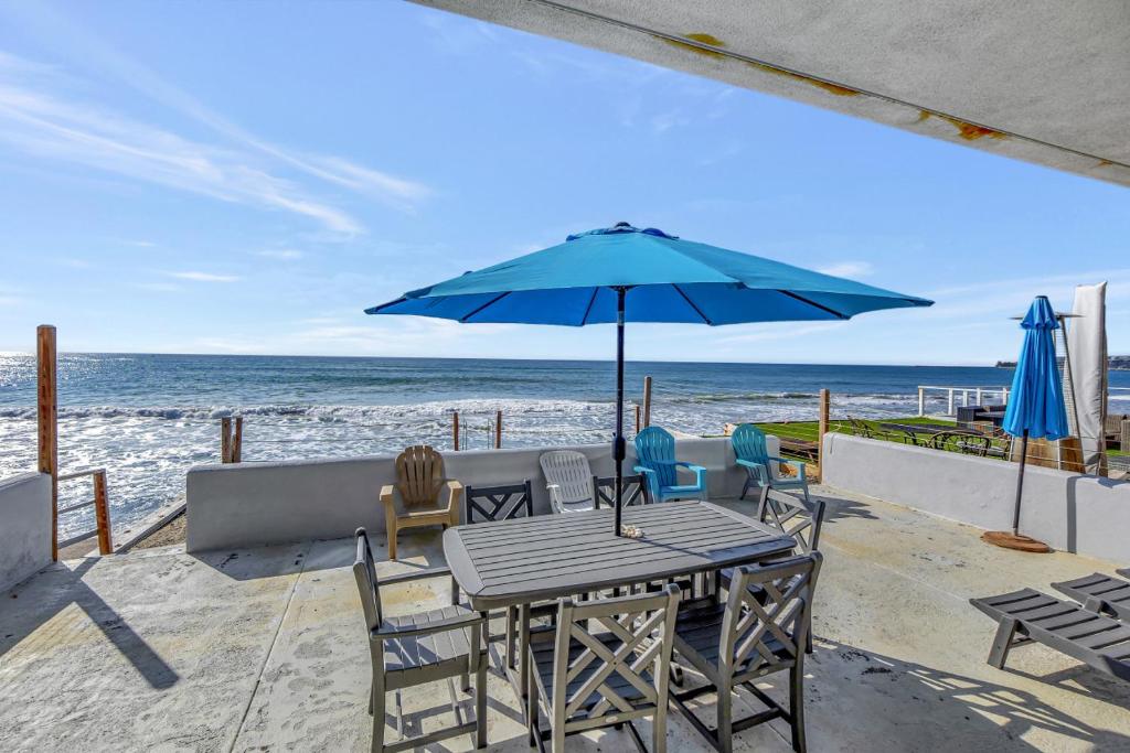 a table and chairs with an umbrella on the beach at OCEAN FRONT - STUNNING VIEWS- VACATION PARADISE!! in Dana Point