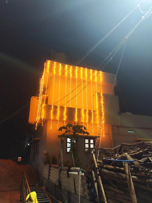 a building with lights hanging from the side of it at Durga Devi Home stay in Hospet