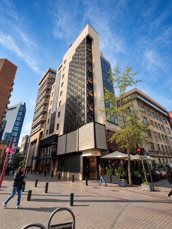 a tall building with people walking in front of it at RQ Costanera Apartments in Santiago