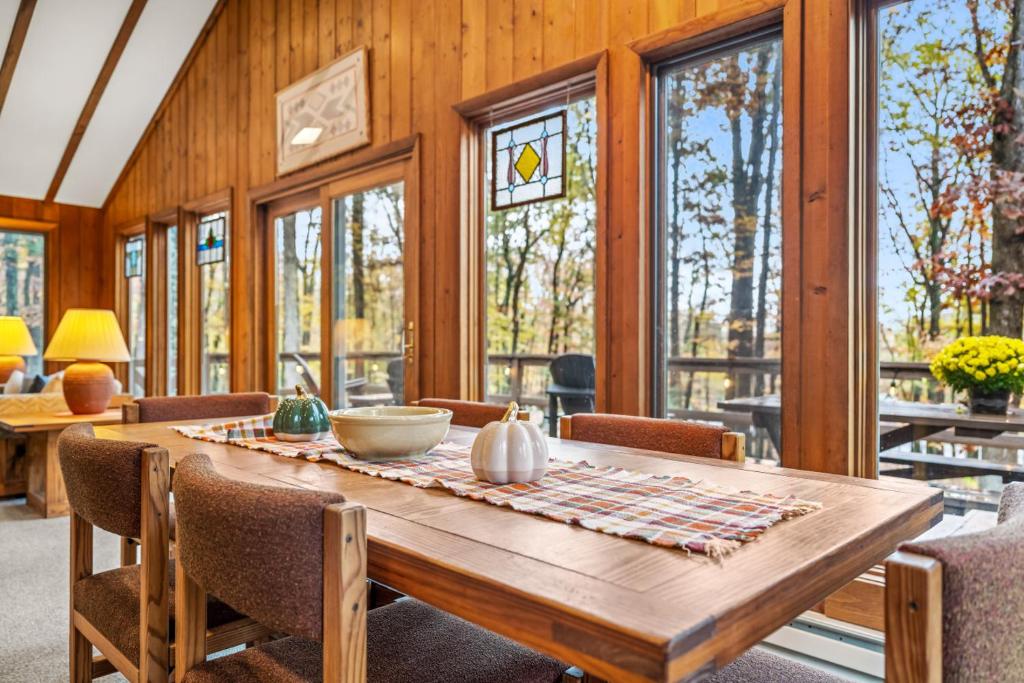 a dining room with a wooden table and chairs at Haven Home - Deck, Grill, Hiking, Pool Access, Games, Community Playground and Tennis Courts in Berkeley Springs