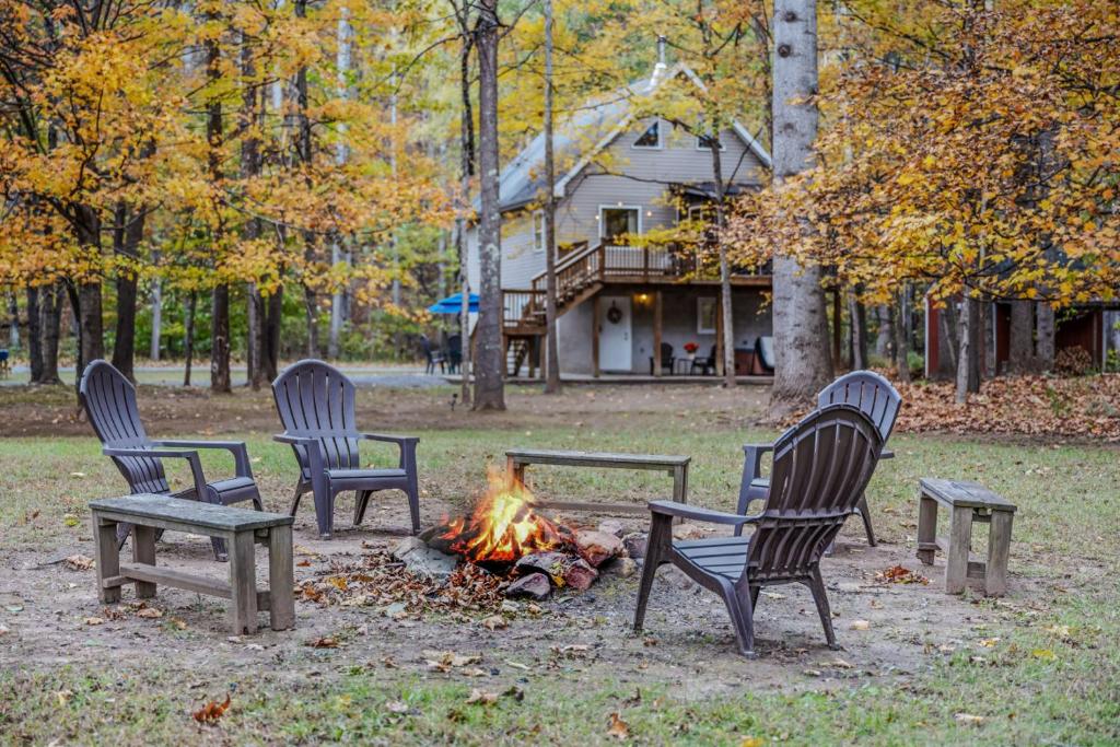 three chairs sitting around a fire in a park at Trails End River Retreat - Riverside in Berkeley Springs