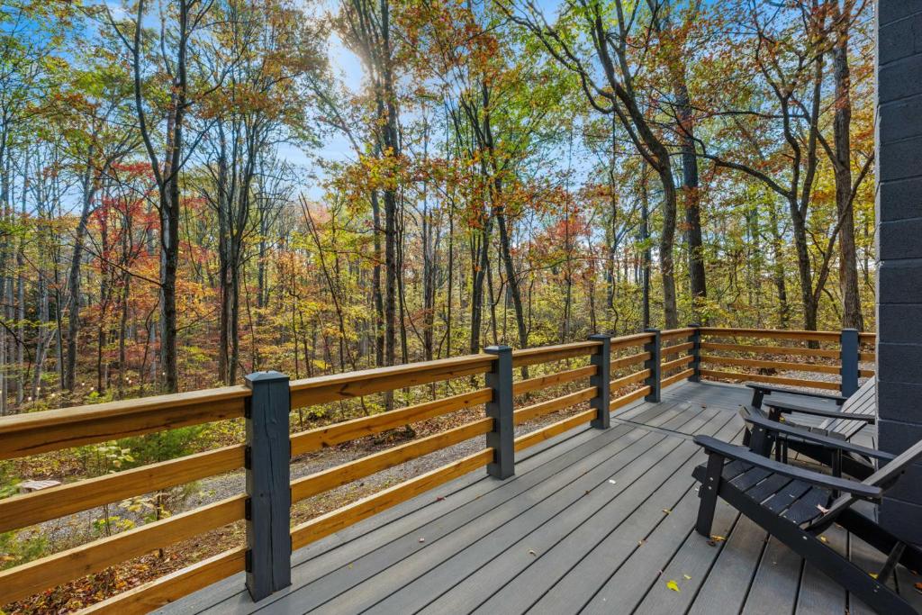 a wooden deck with two benches on it at A Humble Abode - - Pet Friendly, Fire Pit, Deck, Grill, Wood Stove, Games, Wifi, 6 acres in Great Cacapon