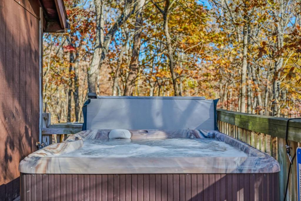 a person laying on a bed in a hot tub at Woods Song -- Hot Tub - Pet Friendly - Wifi - King Bed - Woods Resort - Golf Nearby - Pool Pass - Spa - Grill - Fireplace in Hedgesville