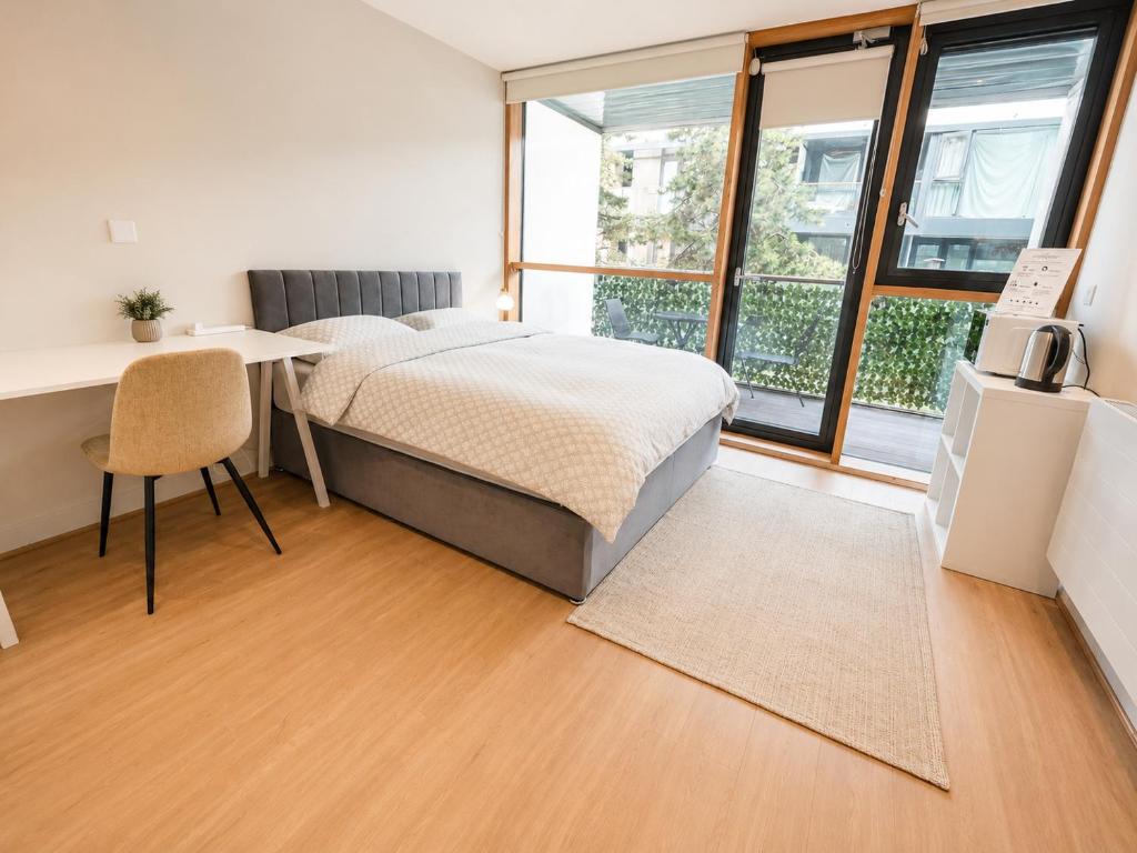 a bedroom with a bed and a desk and windows at Beacon Guest Rooms Sandyford in Sandyford