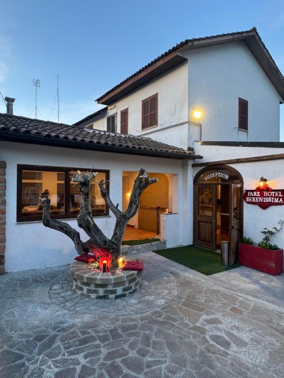 a house with a statue in front of it at Park Hotel Serenissima in Sacrofano