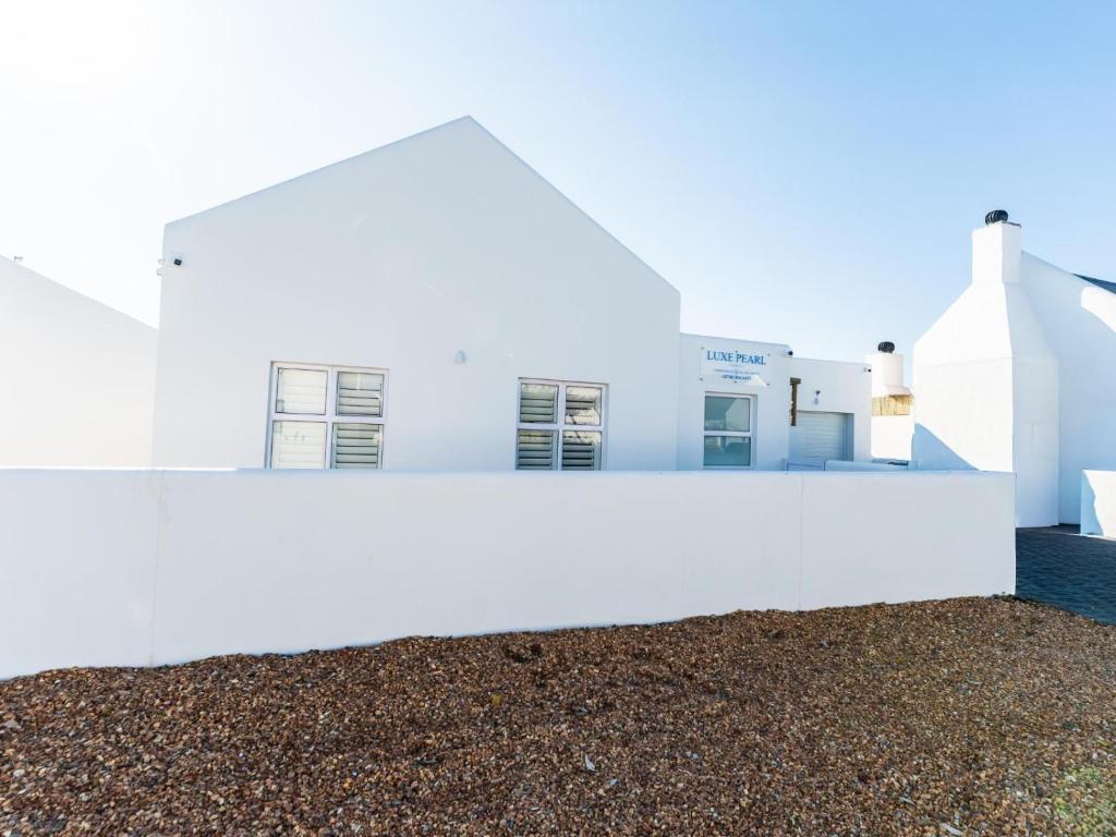 a white building with gravel in front of it at Luxe Pearl in Paternoster