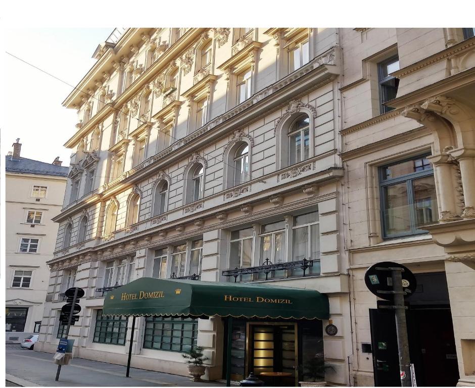 a building on a street with a green awning on it at Hotel Domizil in Vienna