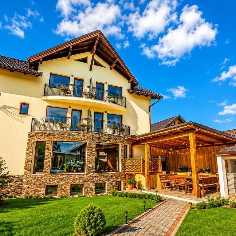 an exterior view of a large house with a deck at Vila Emerald Residence in Râşnov