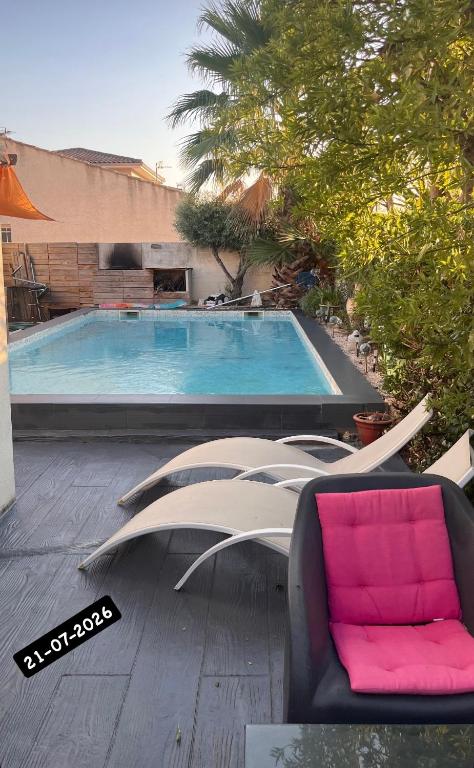 a swimming pool with a chair and a couch at Villa Des Romieux in Pinet
