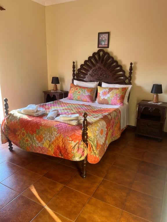 a bedroom with a large bed with a wooden headboard at Propriedade dos Seixos in Moledo