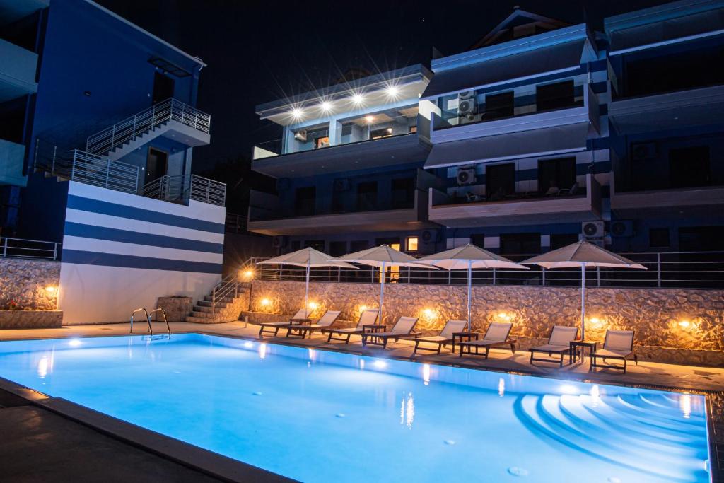 a swimming pool in front of a building at night at Hippothoi Sea View Maisonette in Mesochórion