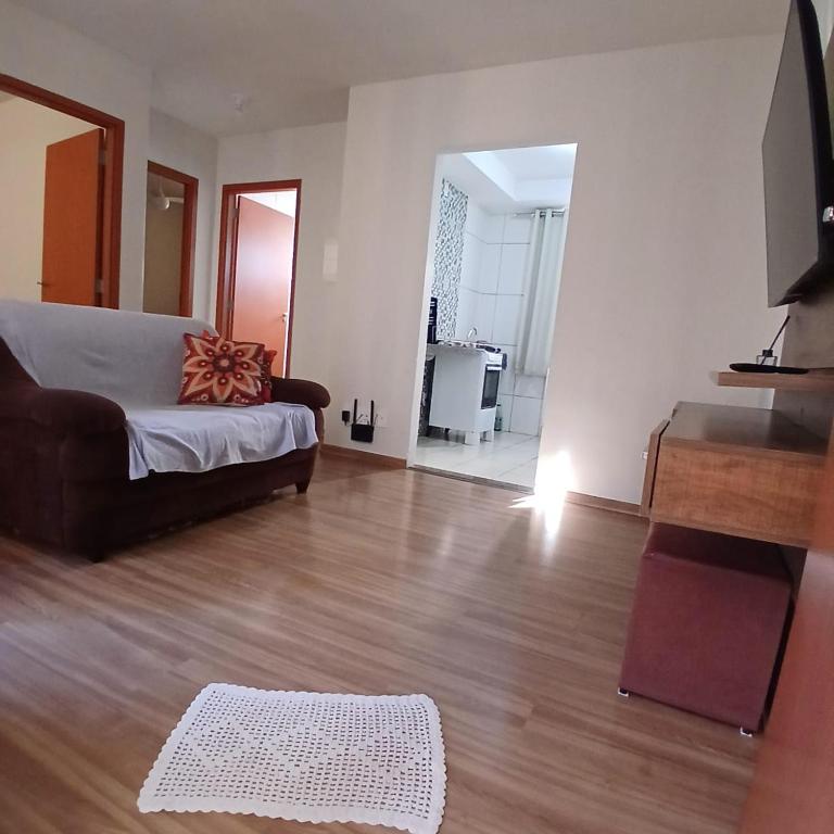 a living room with a couch and a wooden floor at Apartamento Serenidade! in Uberaba